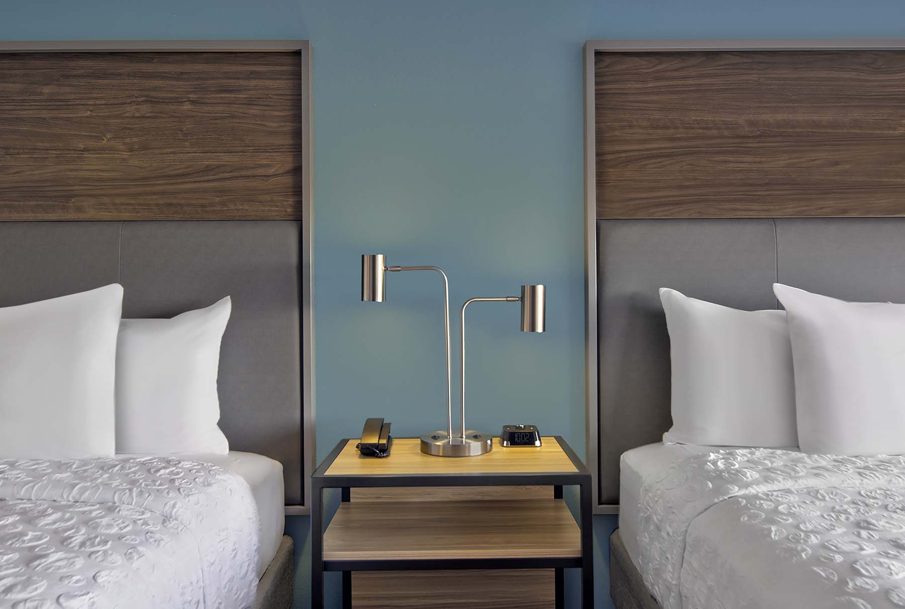 A Hilton hotel room with two beds separated by a nightstand.