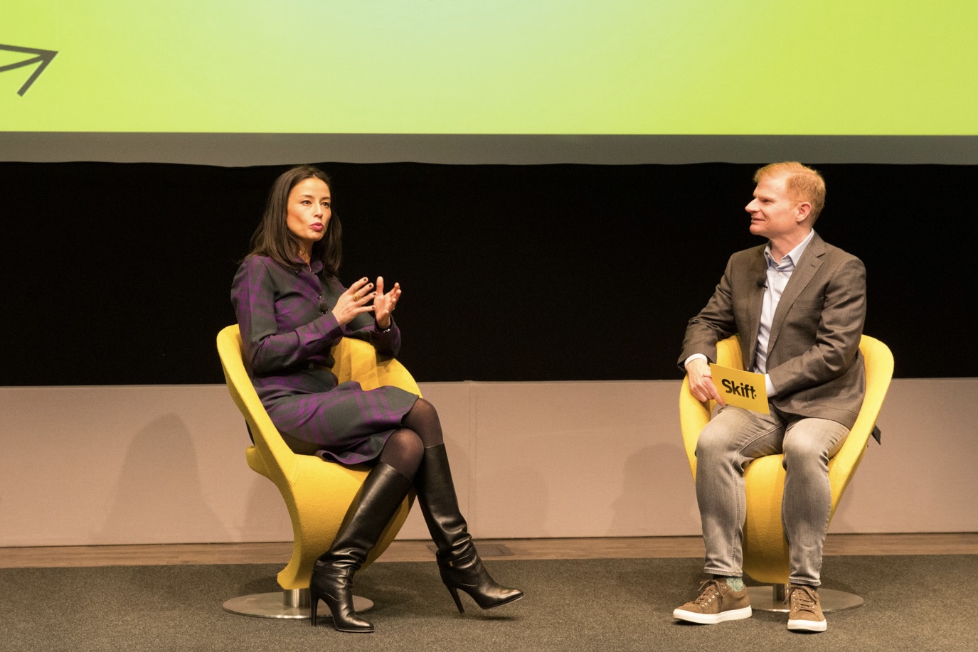 A woman and man speaking on stage
