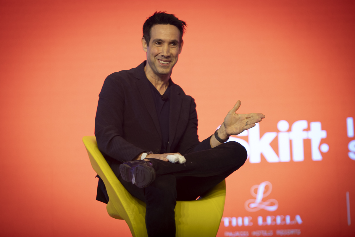 man sitting in a yellow chair on stage