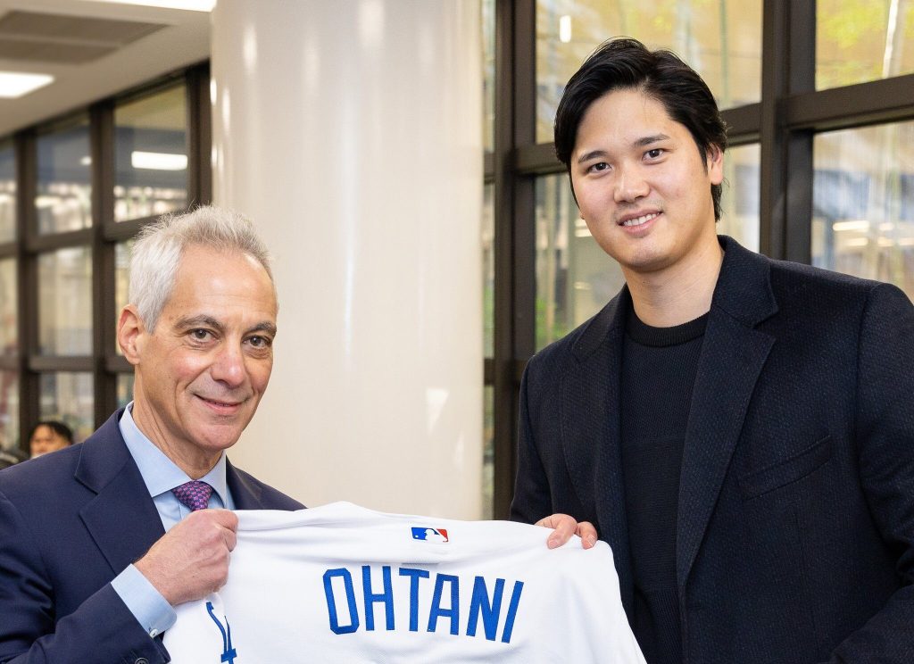 Two people holding a baseball jersey