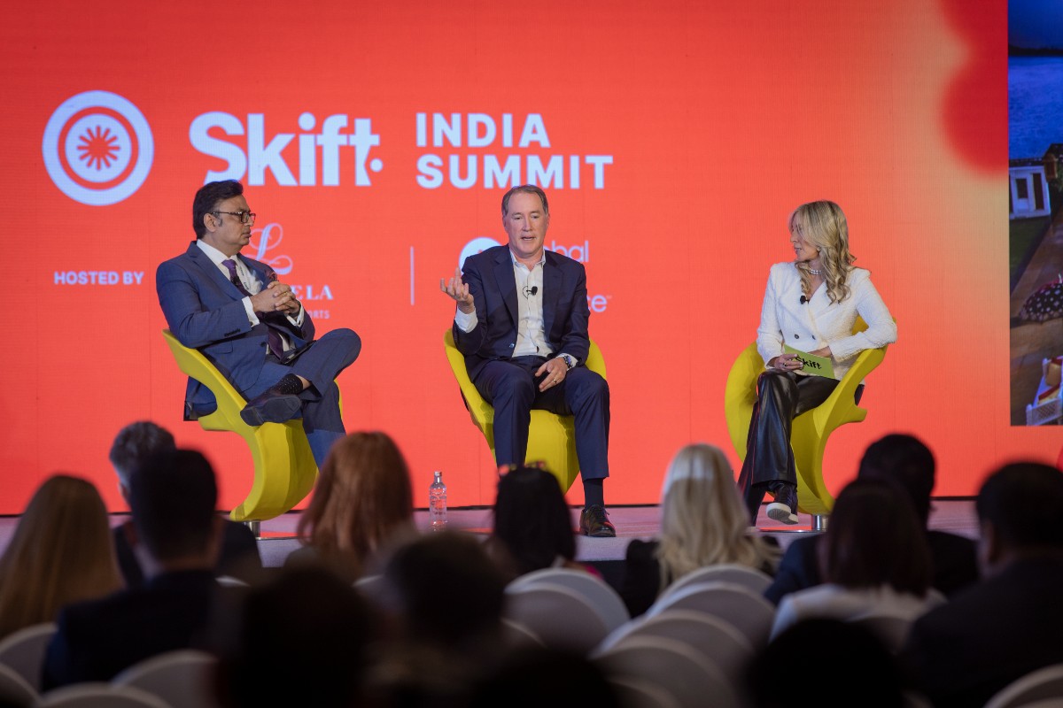 Chris Hartley and Anuraag Bhatnagar on stage with Carolyn Kremins