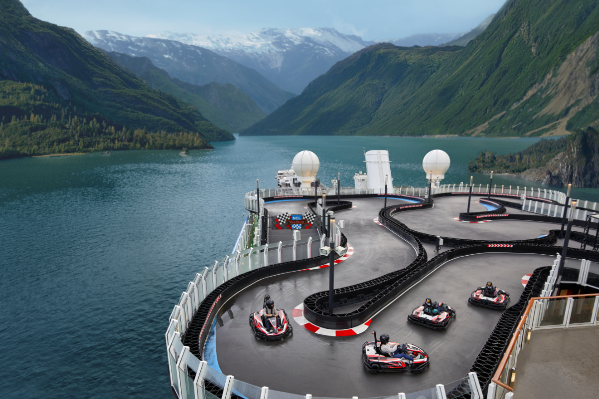 aerial view of a Go kart raceway for kids on top of a Norwegian Cruise Lines cruise ship in a waterway between mountains
