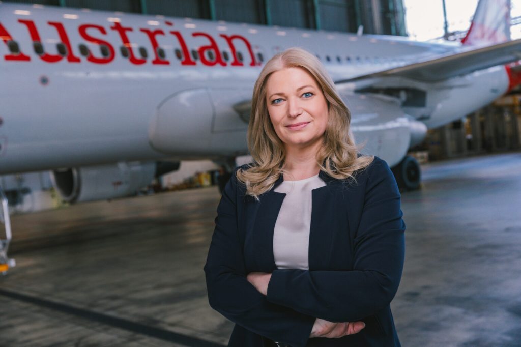Annette Mann - Austrian Airlines CEO beside an airplane.