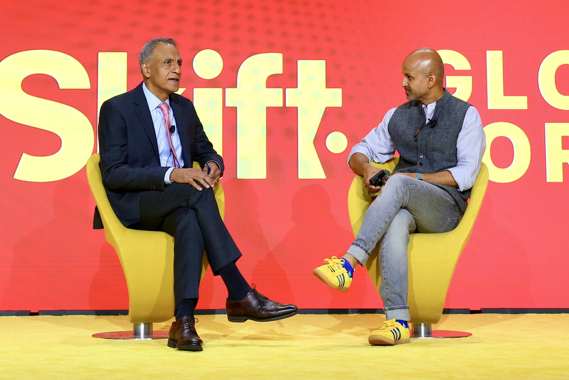 Two men in an interview session on a stage.