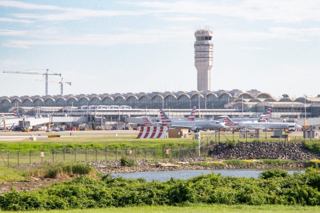 A crowded airport tarmac and air traffic control tower