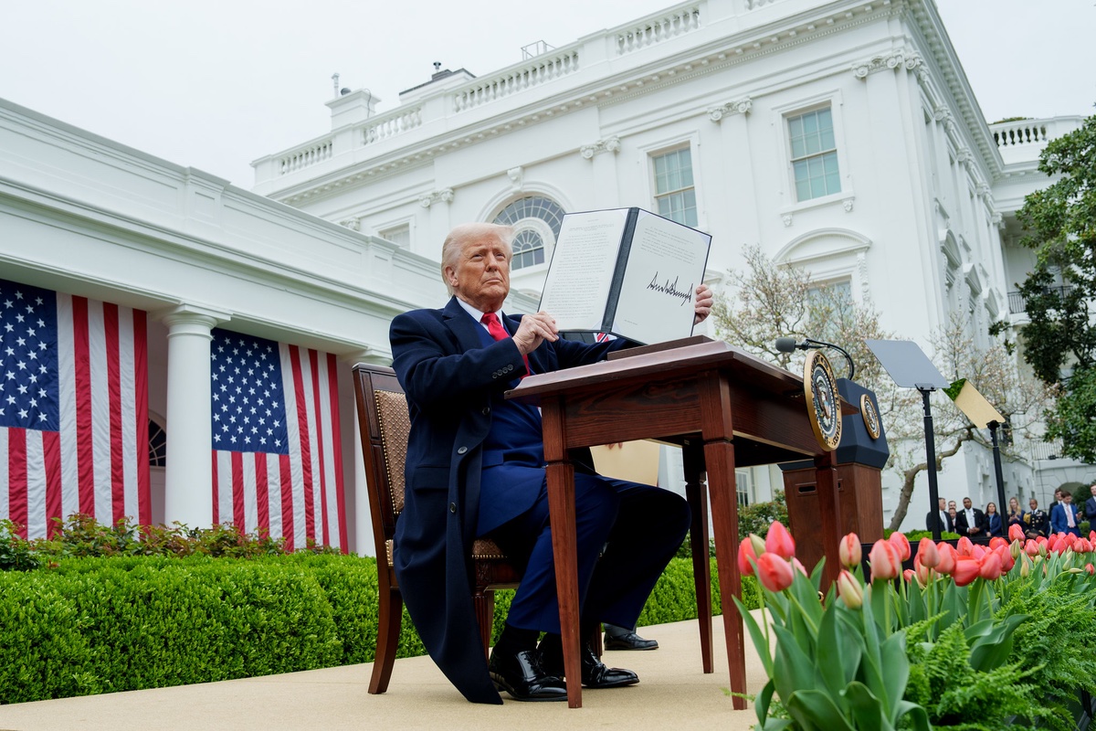 Orange boy in a diaper writing his name in big letters.