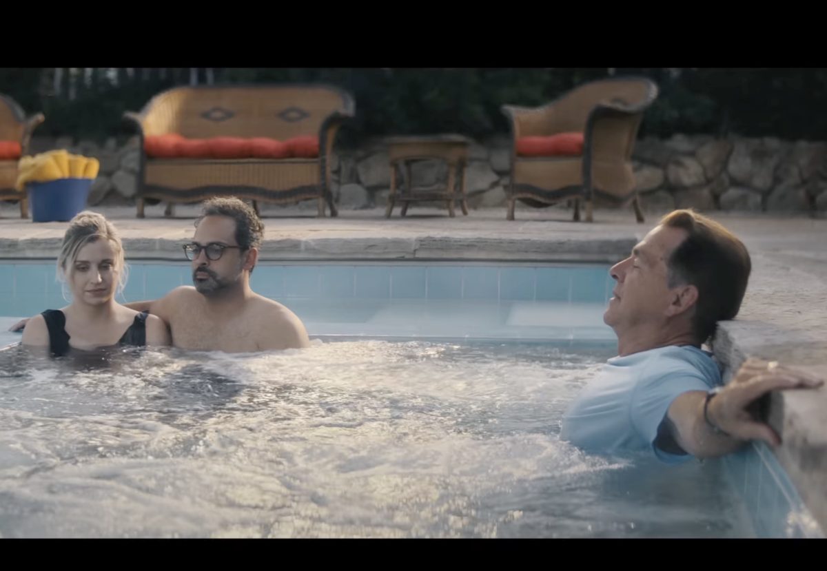 Three people relaxing in a swimming pool. One is Nick Saban, the former Alabama University football coach.
