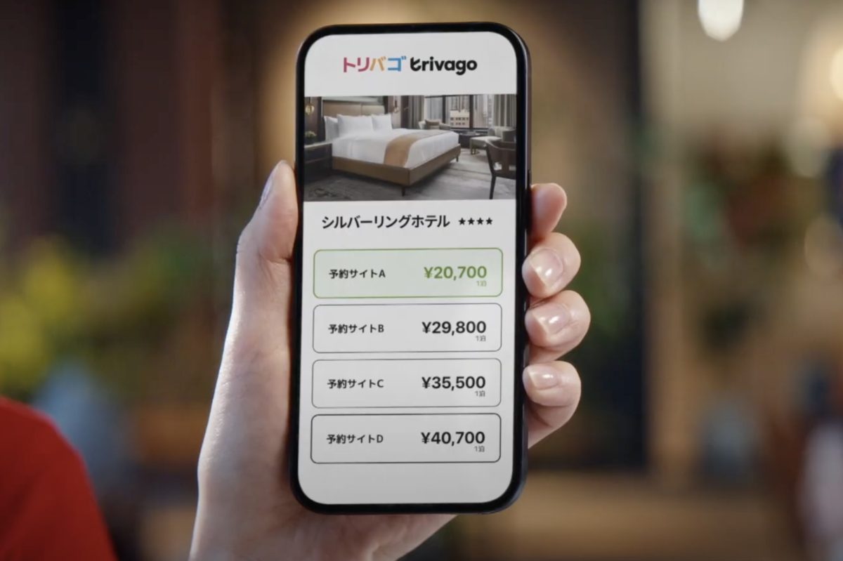 Someone holding a phone that shows the Trivago app in Japanese.