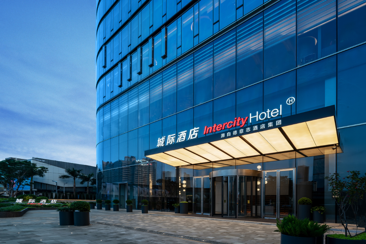 view of a sleek hotel exterior in China with a Mandarin language sign