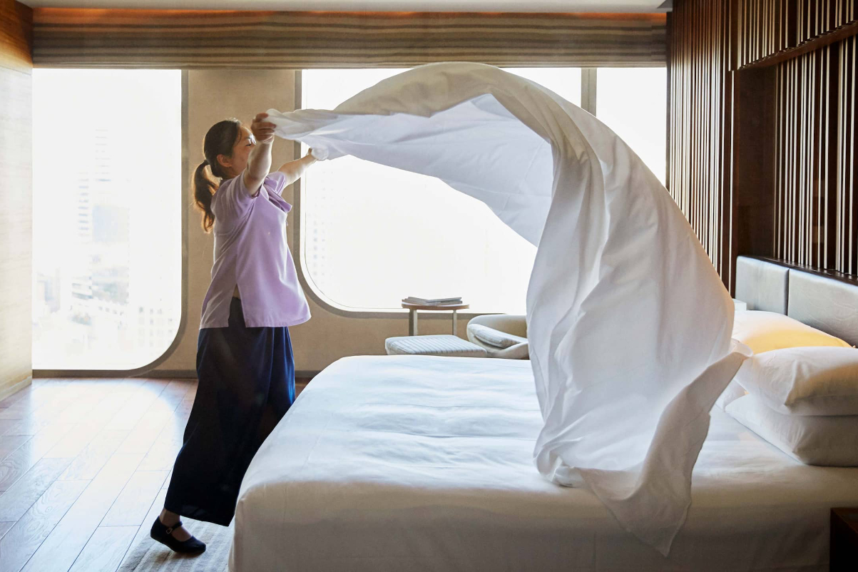 a housekeeper makes a bed in a hotel