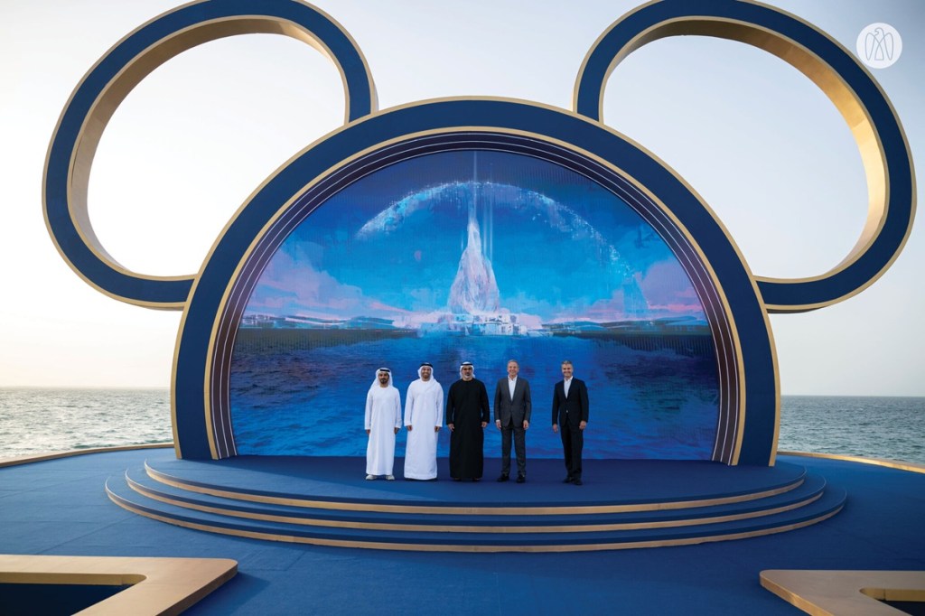 Men standing in front of the Disney logo