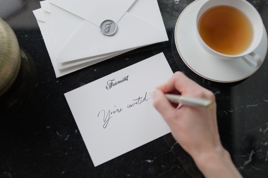 Hand writing an invitation.