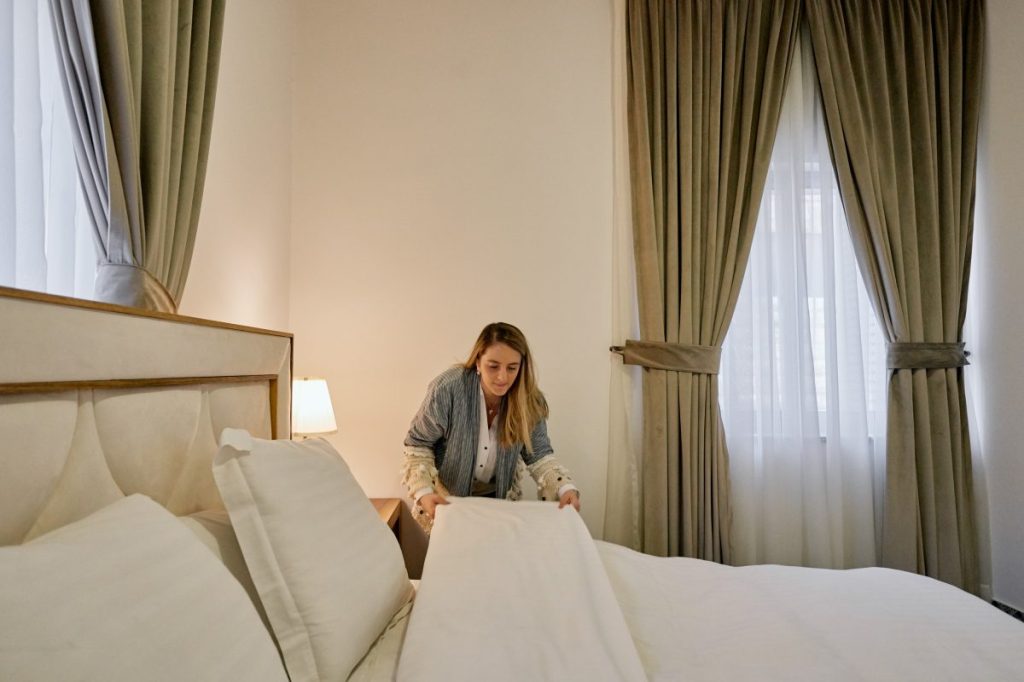 A woman making a bed in an Airbnb in Amman, Jordan.