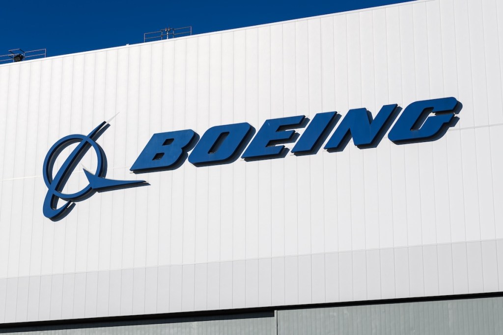 Boeing Corporation logo on a white building with blue sky in Seattle.