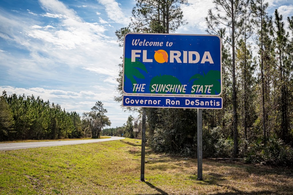 A blue sign reading 'welcome to Florida' on a highway