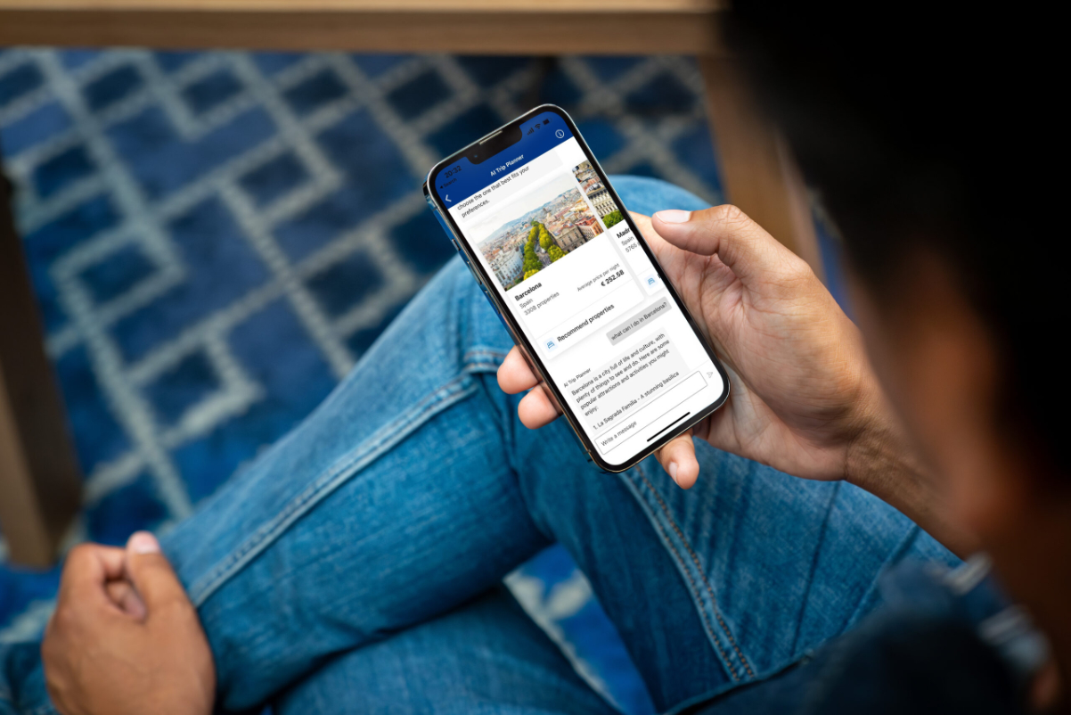 a person holding a phone with the Booking.com app open