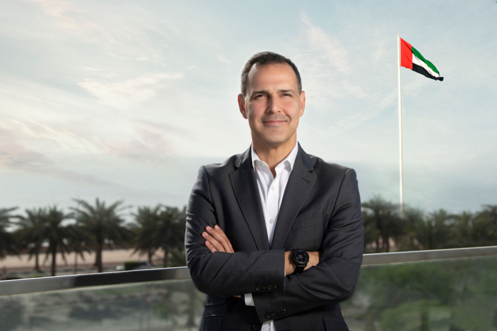 A man standing in front of the UAE flag