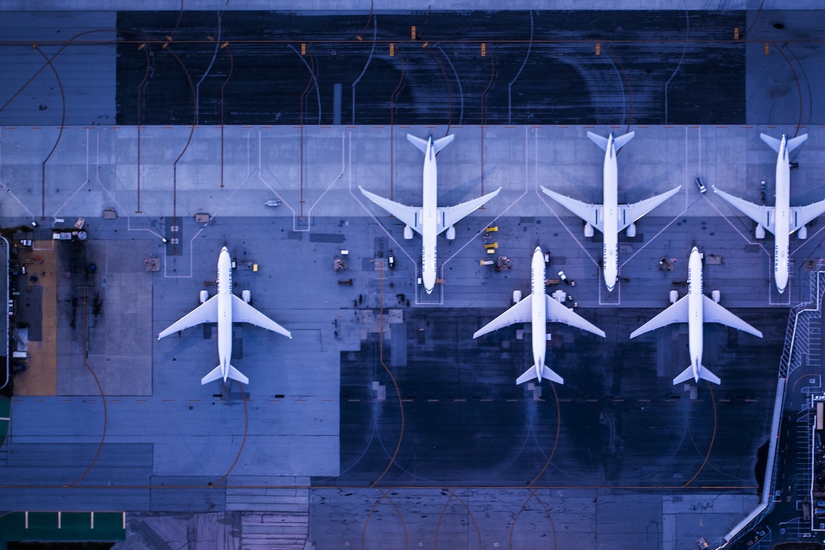 A view from overhead of a half-dozen airplanes on a tarmac.