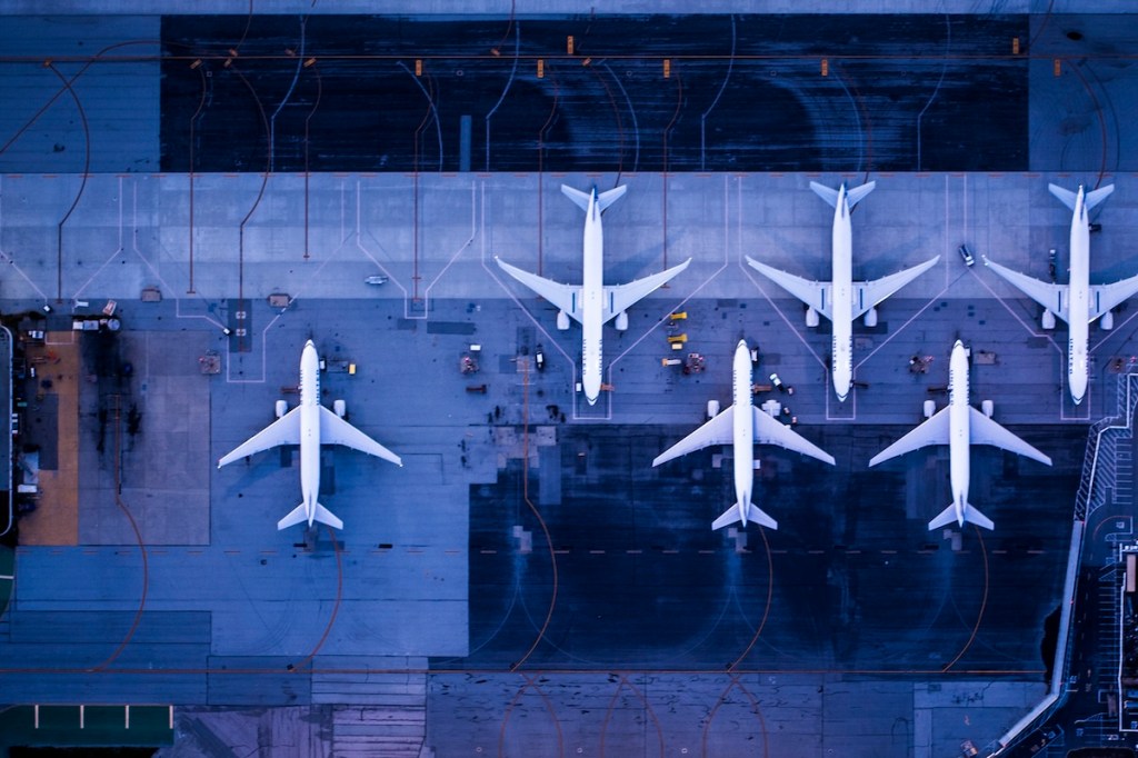A view from overhead of a half-dozen airplanes on a tarmac.
