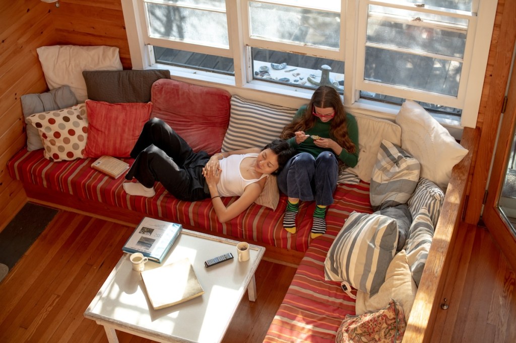 Two people lying and sitting on a sofa in an Airbnb on Fire Island, New York.