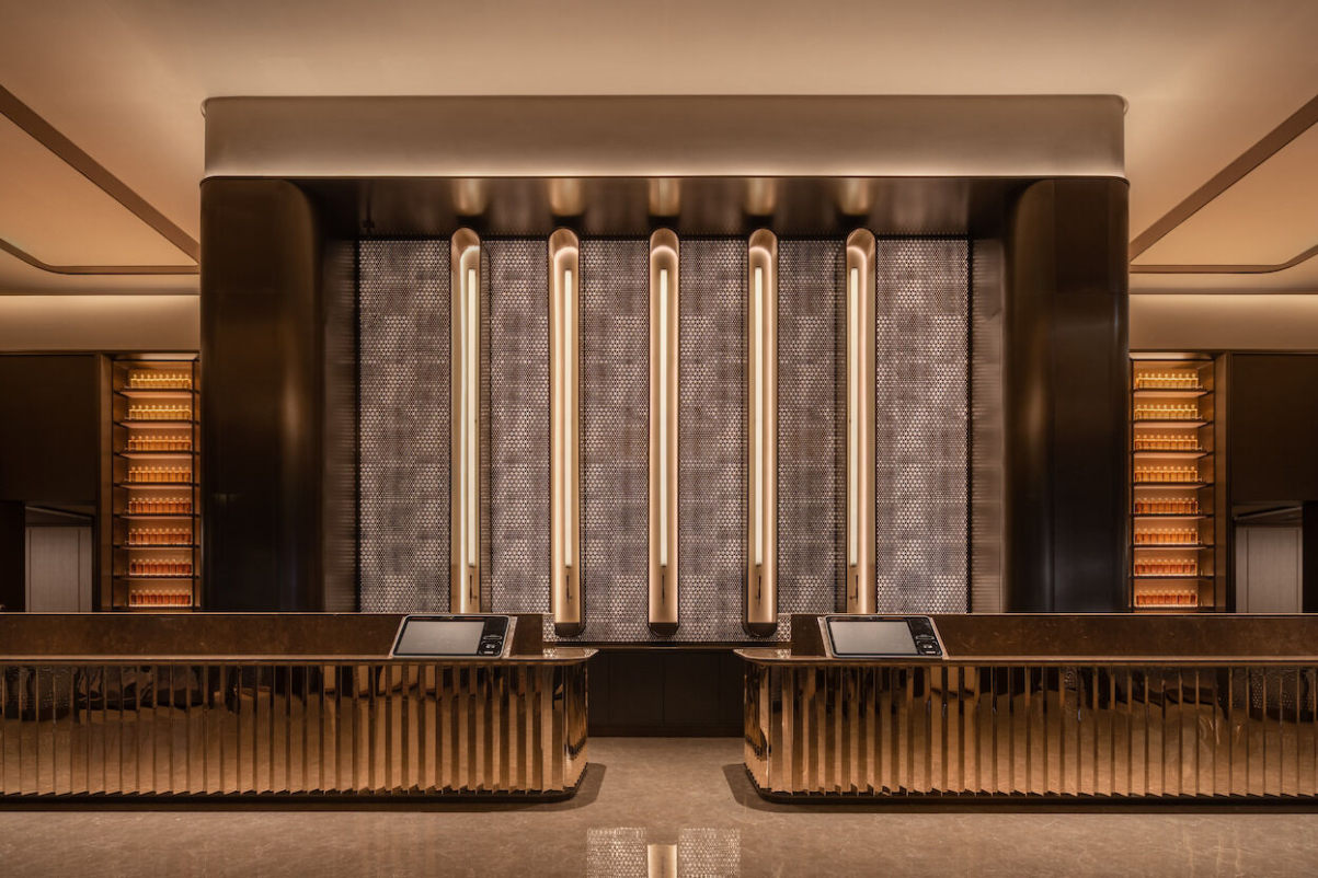 A view inside the lobby of a mid-scale hotel in Shanghai run by H-World. It has vermilion colors and some art deco details.
