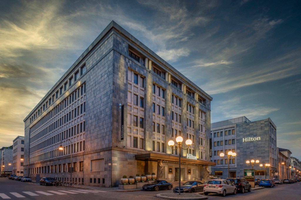 Exterior view of the new Hilton Turin Centre, seen at dusk with its austere edifice.