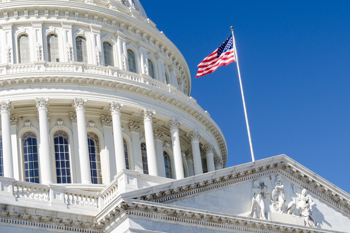 upward view of the dome and flag atop a white marble building