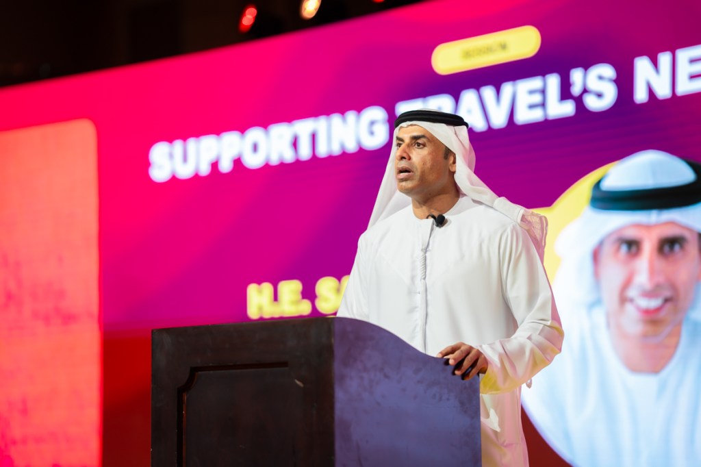 a man speaking on stage behind a podium