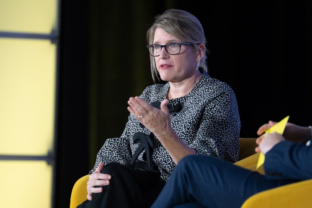 a woman executive of an airline talking onstage at a conference