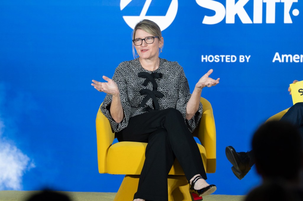a woman executive of an airline talking onstage at a conference