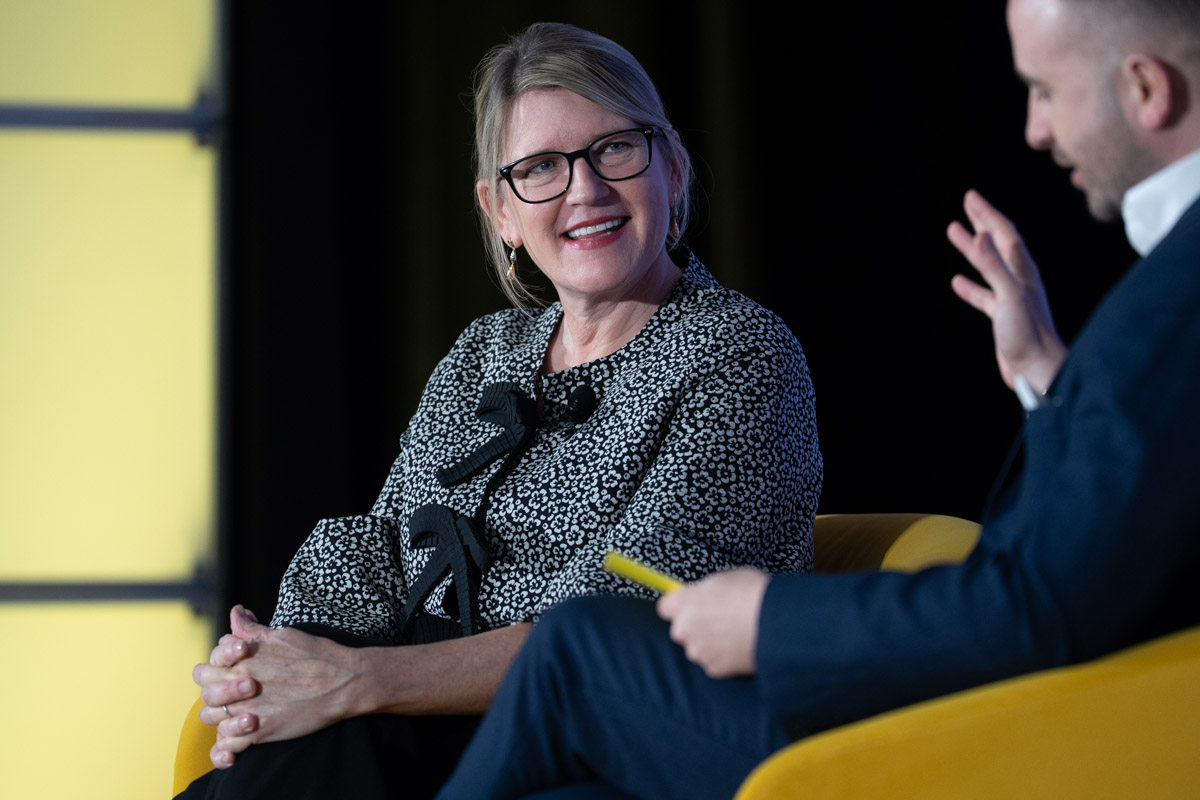 a woman executive of an airline talking onstage at a conference