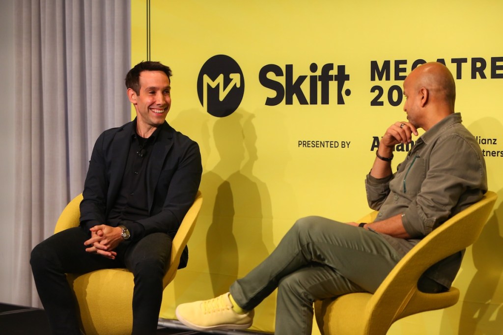 Two men sitting on a stage at a conference.
