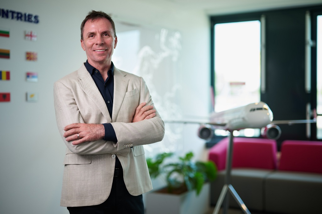 József Váradi, Chief Executive Officer of Wizz beside a Wizz aircraft.