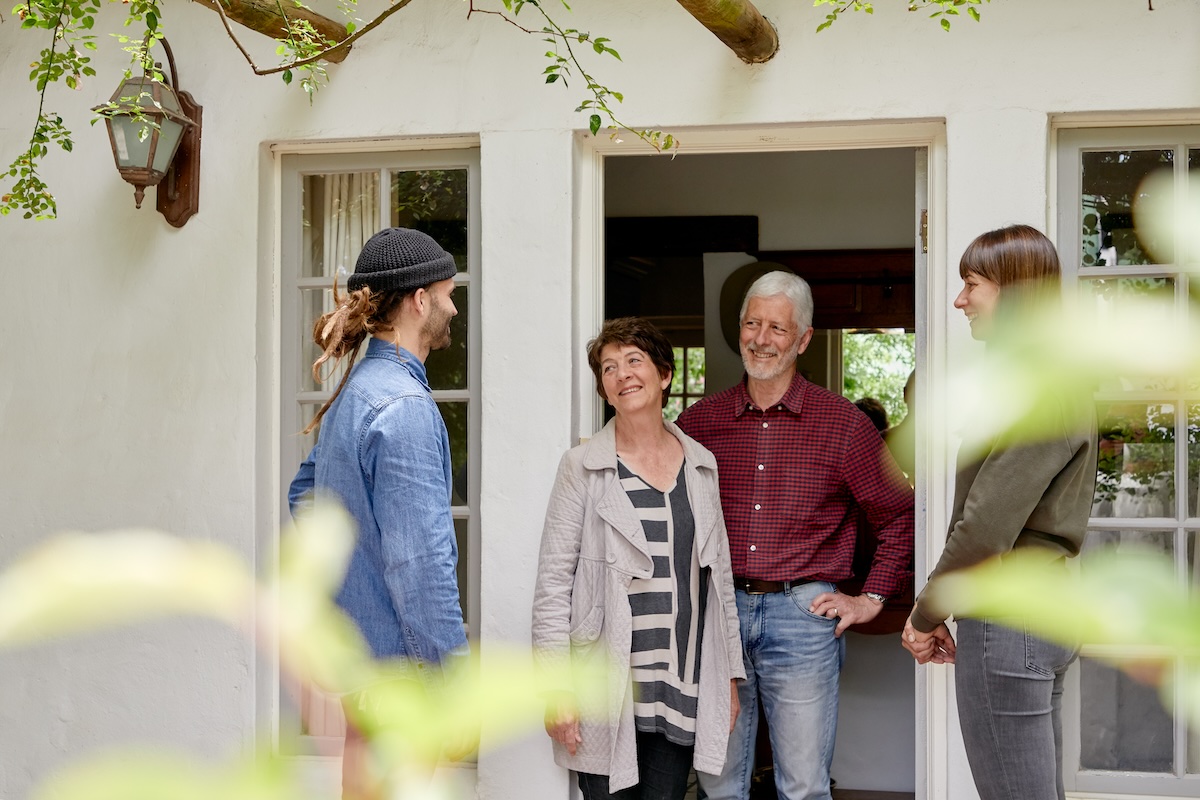 Airbnb guests standing and talking in a doorway of a home in Cape Town, South Africa.