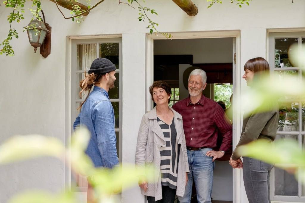 Airbnb guests standing and talking in a doorway of a home in Cape Town, South Africa.