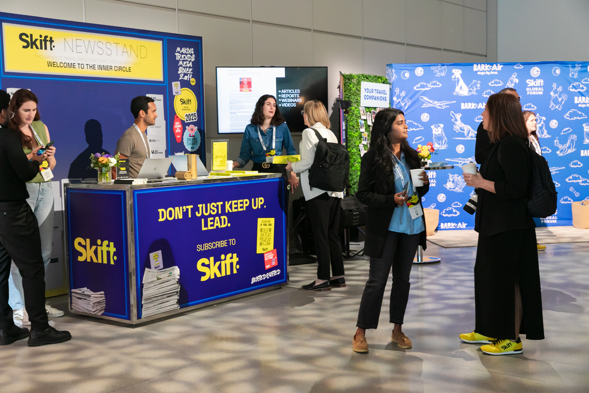 Attendees gathered around the Skift Newsstand at Skift Global Forum, with Skift IDEA Awards displays and branded materials visible.