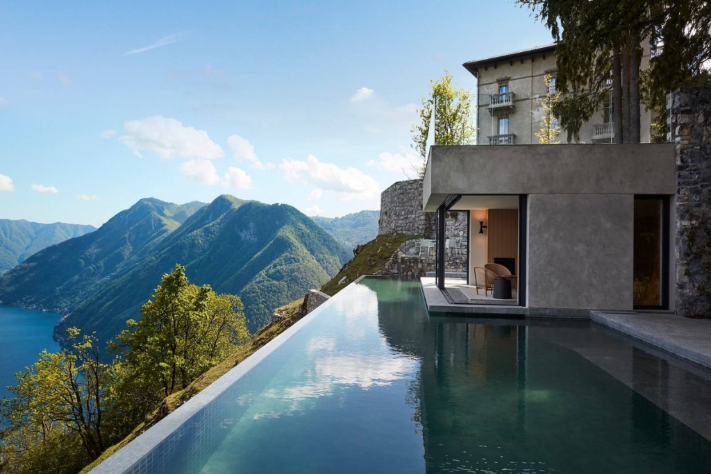 Image of an infinity swimming pool overlooking the mountains in Lake Como, Italy, seen from a luxury villa during the day