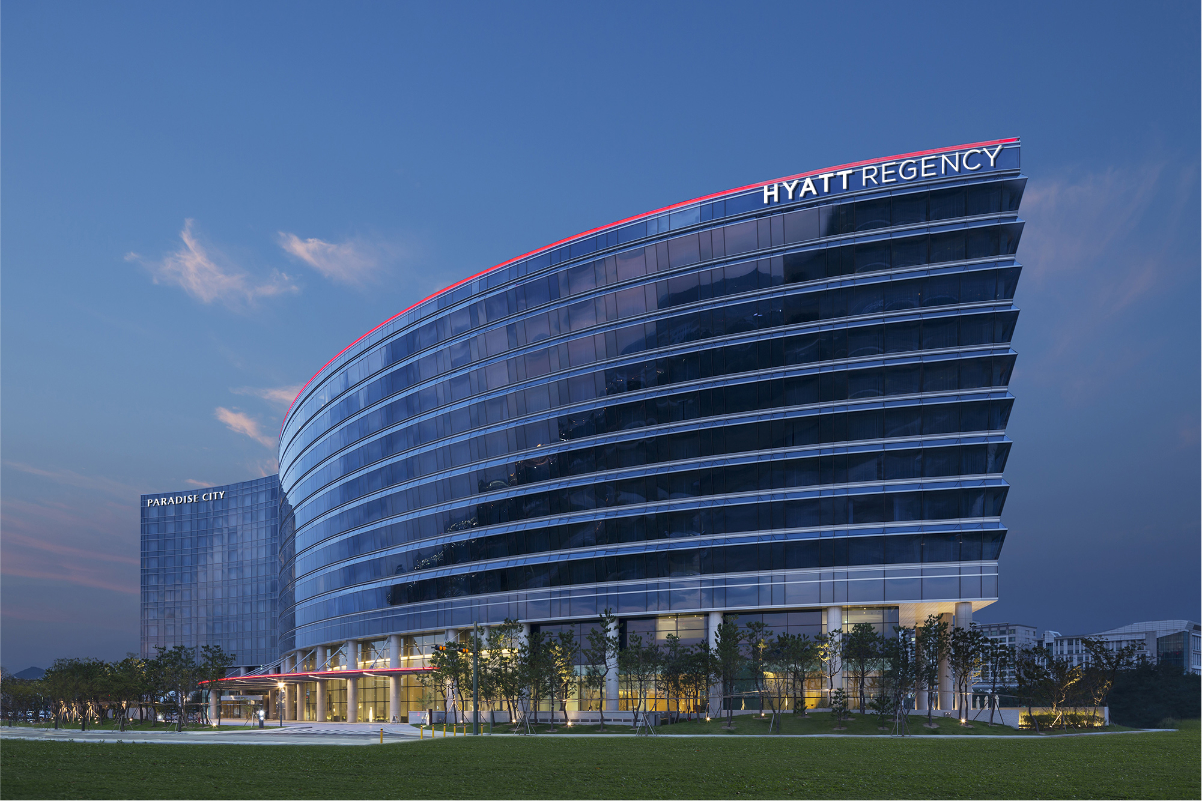 Image of a hotel exterior on a blue sky day showing the Hyatt Regency in Incheon, Korea.