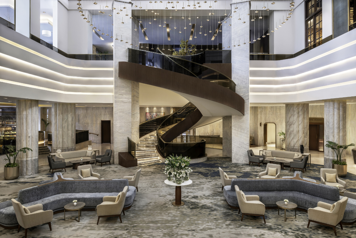 view of a luxury hotel lobby with a spiral staircase in the middle and touches of Arabic decor