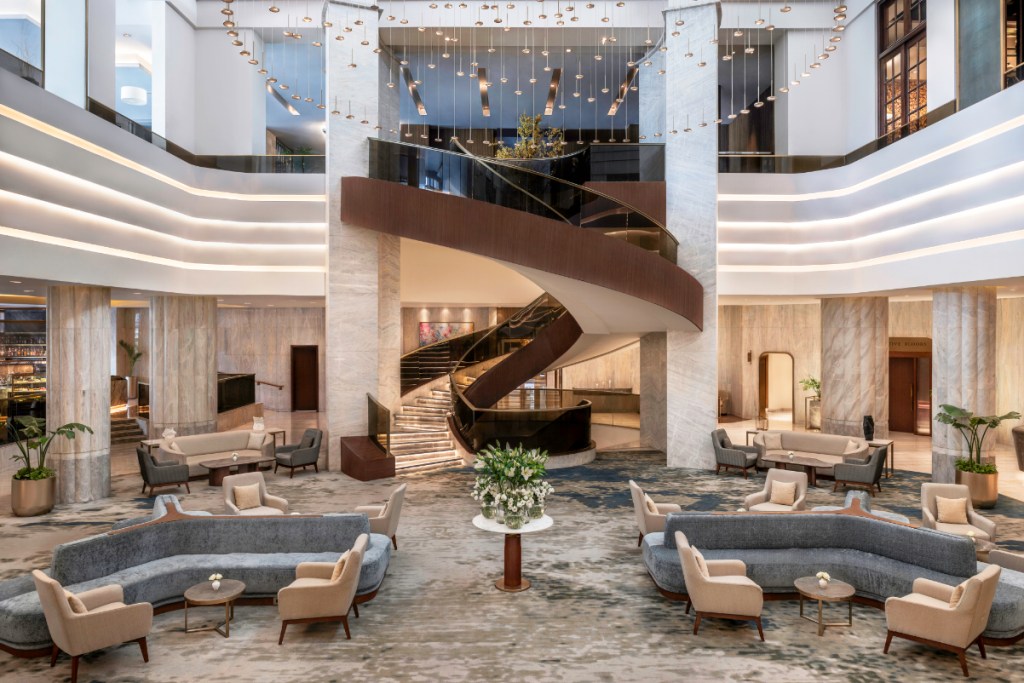 view of a luxury hotel lobby with a spiral staircase in the middle and touches of Arabic decor