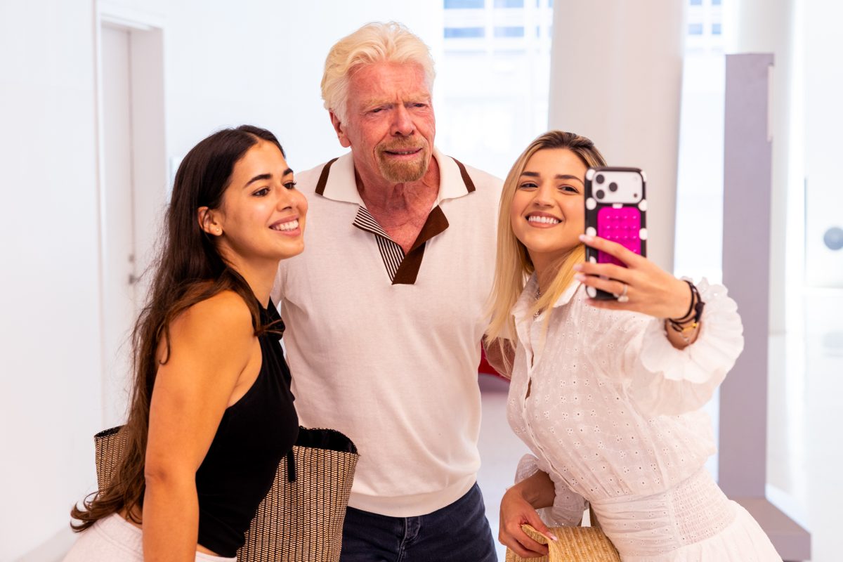 Richard Branson, founder of Virgin Group, poses for a selfie with two content creators.