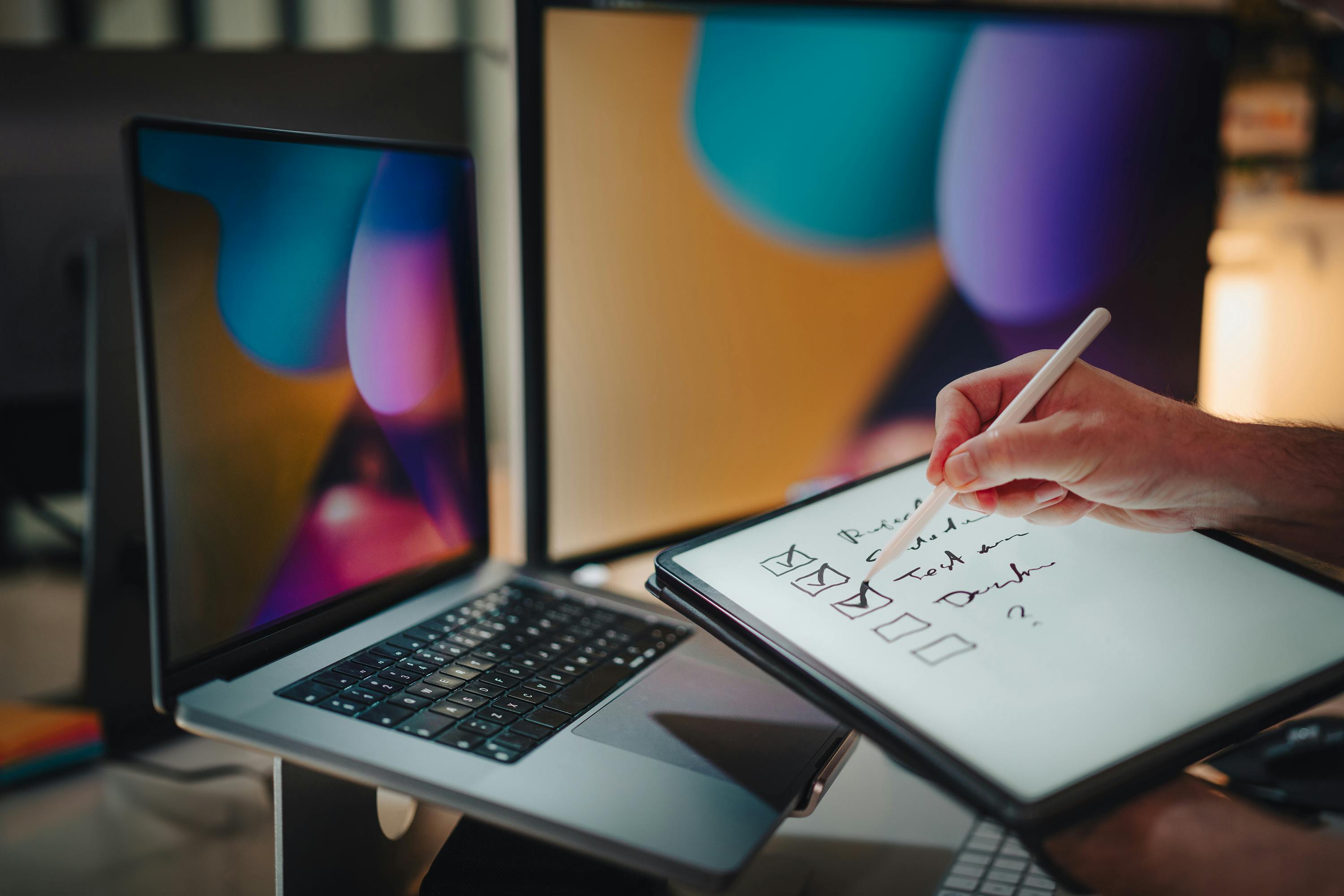 a business professinal using a laptop and a tablet with checklist