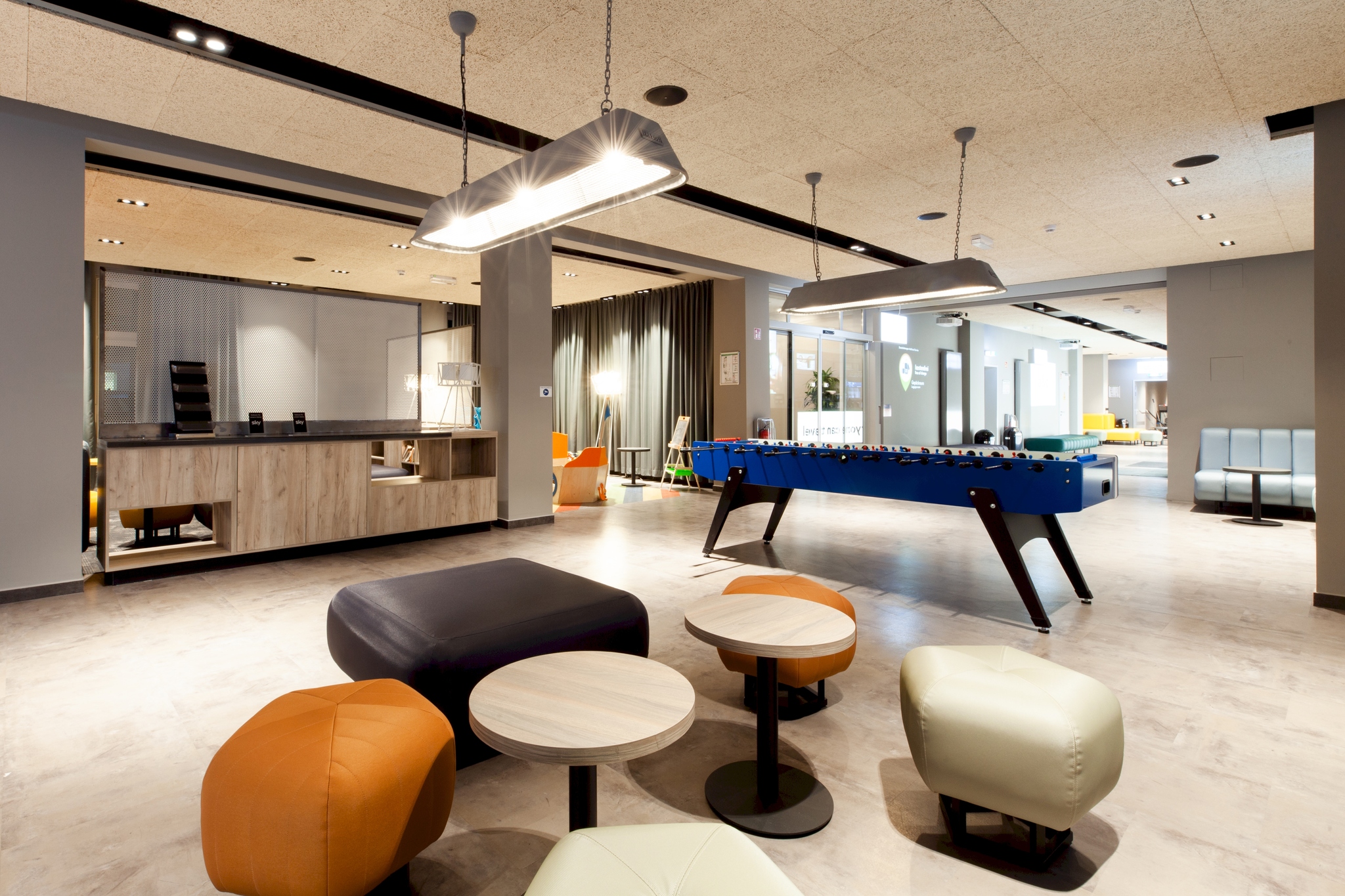 image of the lobby of a modern hostel with chairs and a pool table