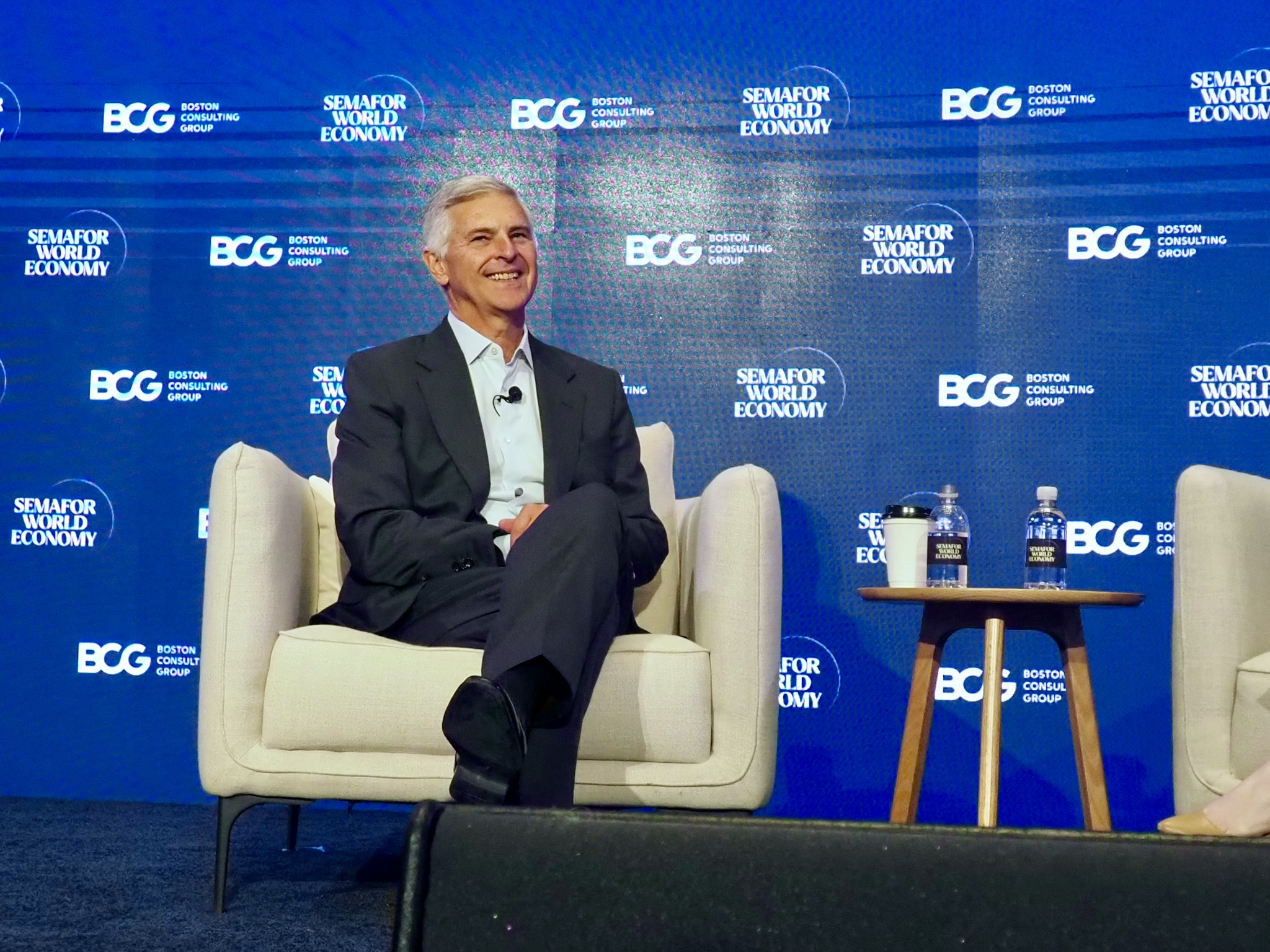 an executive laughing on-stage while seated and being interviewed. it's chris nassetta, ceo of Hilton