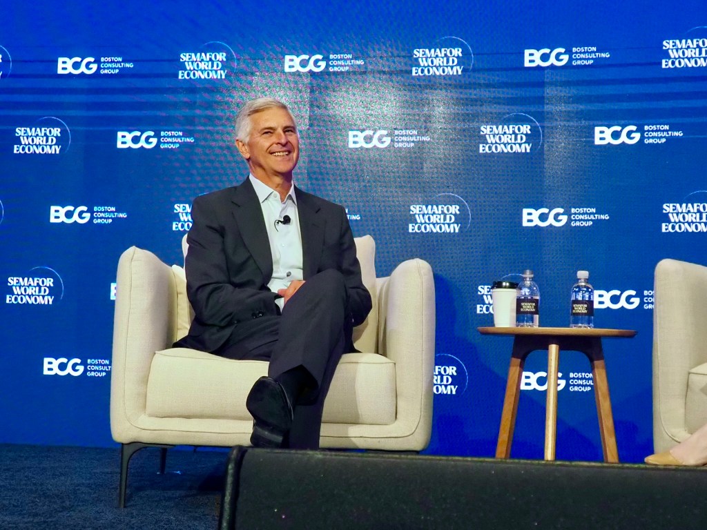an executive laughing on-stage while seated and being interviewed. it's chris nassetta, ceo of Hilton