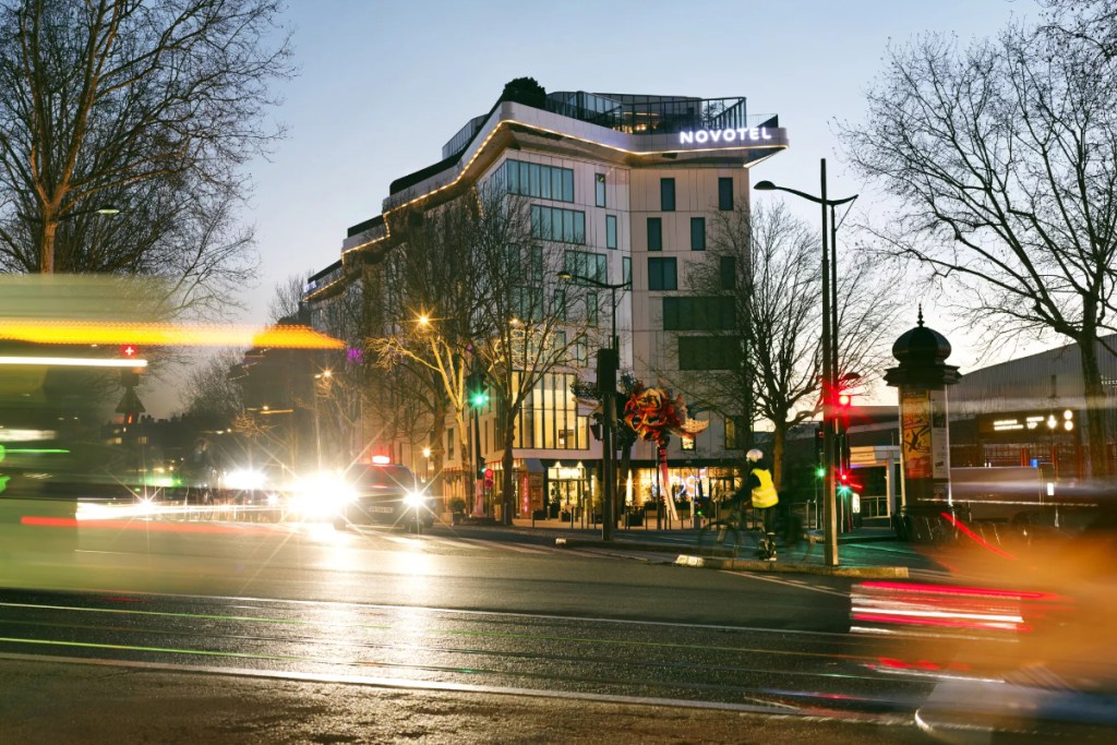 Exterior view of a Novotel at dusk.