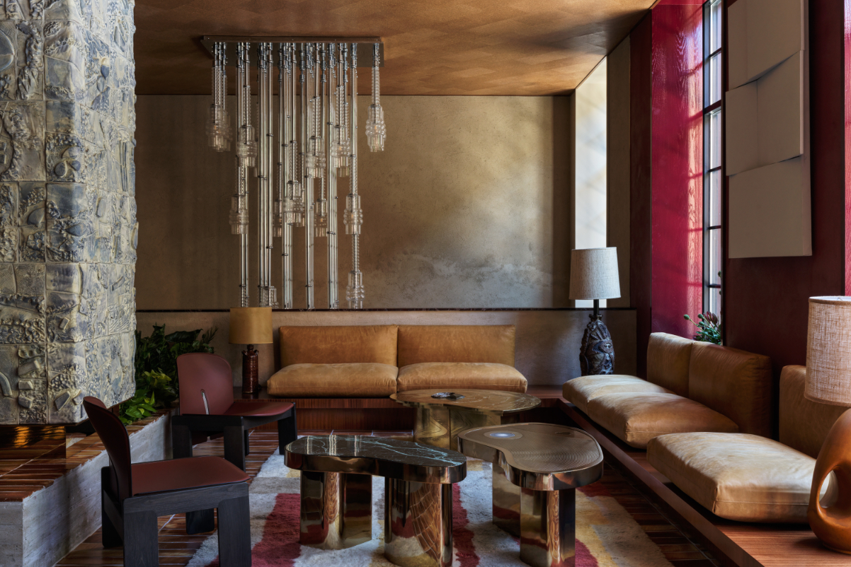 view of low-slung leather couches and unusual looking chandeliers in a members club at The Manner boutique hotel in New York's Soho neighborhood.